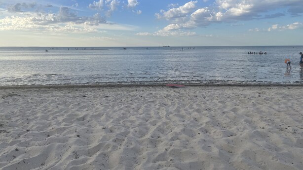 En strand med en sandstrand och en klar himmel.