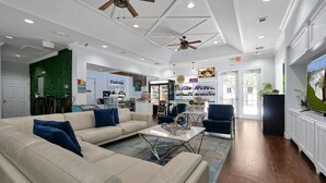 A spacious living area with a beige sofa, a coffee table, and a ceiling fan.