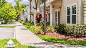 A row of townhouses with a sidewalk, greenery, and a fire hydrant.