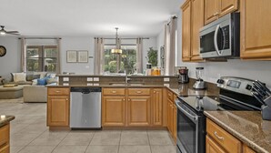 Une cuisine moderne avec des meubles en bois, des appareils en acier inoxydable et un îlot central.