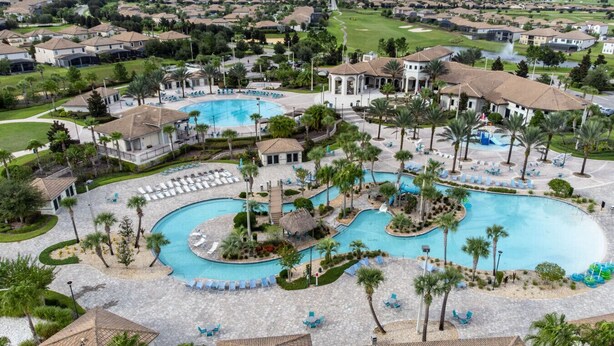 Un complexe hôtelier doté de plusieurs piscines, de palmiers et, au loin, d’un terrain de golf.