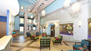 Eine geräumige Lobby mit hoher Decke, mehreren Sitzbereichen und einer Bar/Lounge.