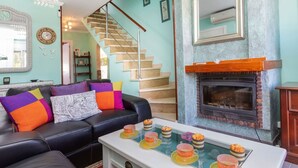 A living room with a fireplace, a staircase, and a coffee table with decorative items.