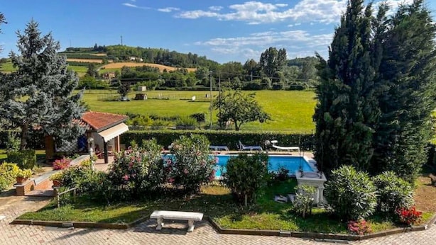 A pool area with a bench, surrounded by greenery and a view of a hilly landscape. - Beautiful private villa for 4 people with A/C, private pool, WIFI, TV, patio and pets allowed (Montaldo Scarampi)
