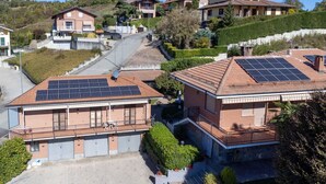 A residential area with houses featuring solar panels on the roofs, a paved driveway, and a hilly landscape. - Beautiful private villa for 4 people with A/C, private pool, WIFI, TV, patio and pets allowed (Montaldo Scarampi)