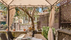 A covered outdoor dining area with a table, chairs, and a pergola. - Lovely apartment for 4 guests with A/C, WIFI, patio and pets allowed (Bellano)