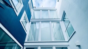 A modern building with multiple windows and a clear sky. - Partenope Hostel and Suites (Angra do Heroismo)