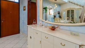 A bathroom with a large mirror, a wooden door, and a tiled floor. - Wonderful  villa for 8 guests with WIFI, TV and balcony (Porto Ceresio)