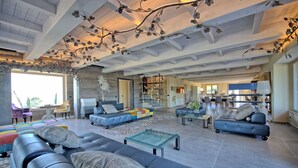 A spacious living room with a high ceiling, a large sofa set, a coffee table, and a dining area. - Stunning private villa for 12 people with WIFI, private pool, A/C, TV, patio and panoramic view (Villamagna)