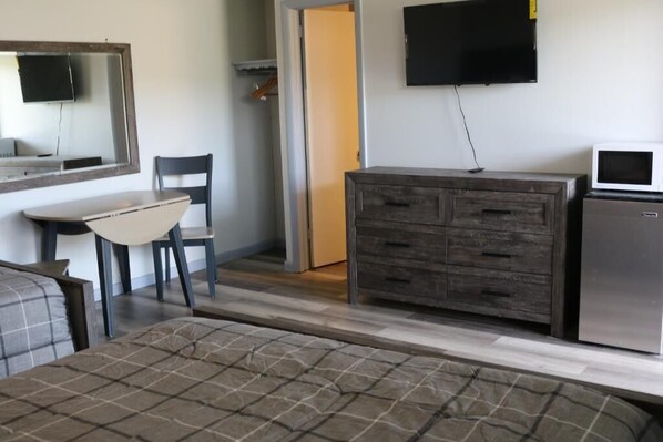 A room with a bed, a dresser, a TV, and a microwave. - Motel 81 (Dalton)