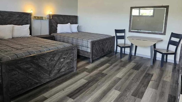 A hotel room with two beds, a small table, and chairs. - Motel 81 (Dalton)