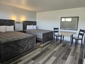 A hotel room with two beds, a small table, and chairs. - Motel 81 (Dalton)
