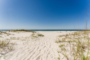 Une plage de sable fin sous un ciel dégagé.