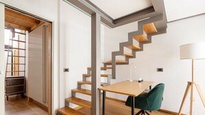 A modern interior with a wooden staircase, a dining table with chairs, and a floor lamp. - GuestHost - Apartment on 2 levels Milan-Crocetta M3! (Milano)