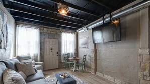 A cozy living room with a sofa, chairs, a small table, and a fireplace. - Belle Plain Inn Rustic Refuge (Baird)