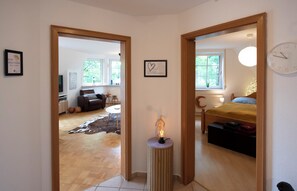 A bedroom with a bed, bedside table, and a clock on the wall. - Cozy heath idyll in the countryside (Schneverdingen)
