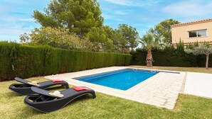 A swimming pool with lounge chairs and a palm tree.