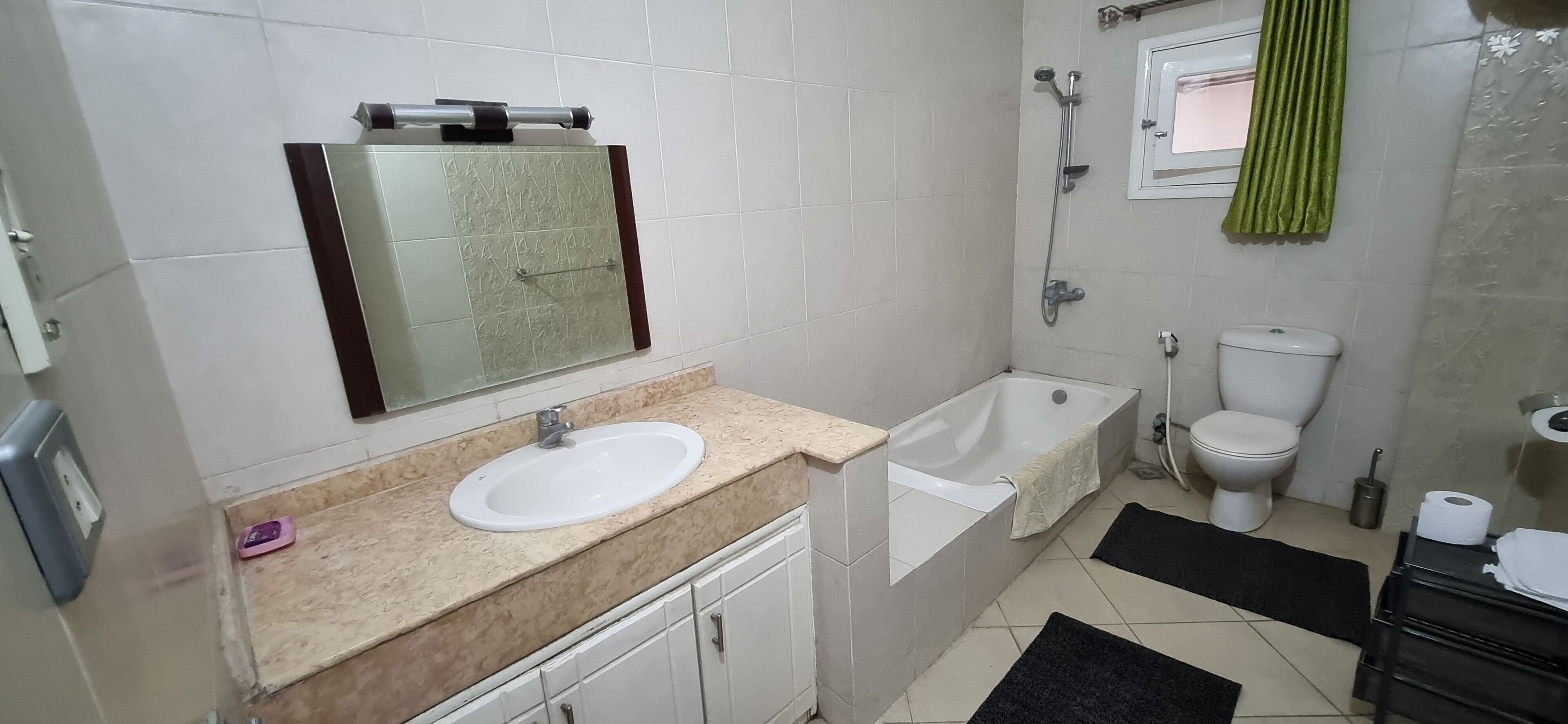 Ein Badezimmer mit Waschbecken, Spiegel, Toilette, Dusche und Badewanne.