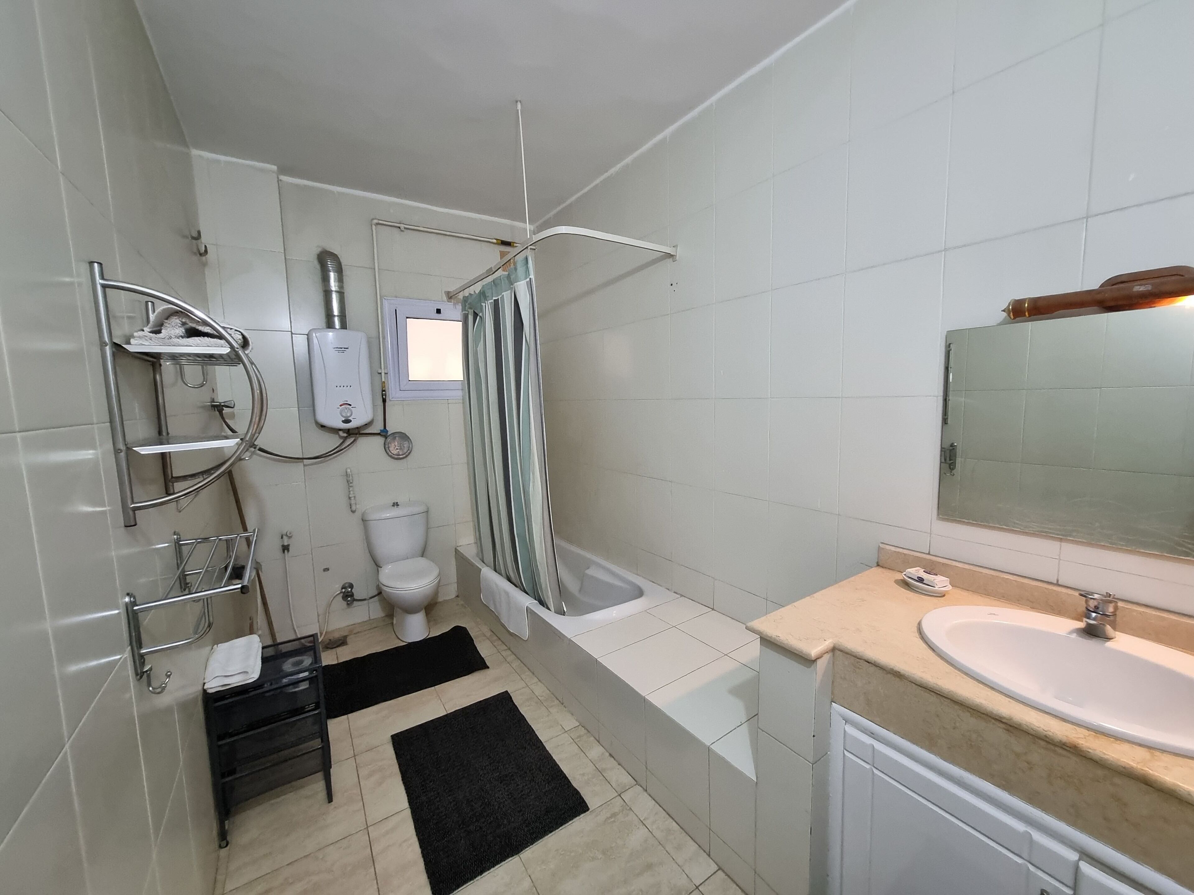 A modern bathroom with a toilet, shower, and sink.