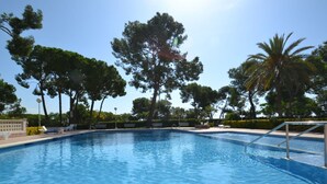 A clear blue swimming pool surrounded by trees and sun. - Beautiful apartment for 6 people with WIFI, pool, A/C, TV, terrace and pets allowed (Salou)