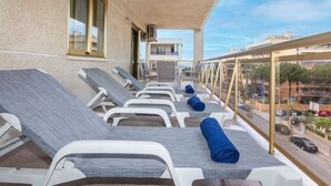 A balcony with sun loungers and a view of the city. - Beautiful apartment for 6 people with WIFI, pool, A/C, TV, terrace and pets allowed (Salou)
