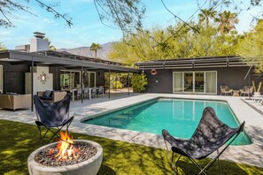 A modern outdoor pool area with a fire pit, lounge chairs, and a covered patio. - Earthy Modern Main House + Casita- Dogs OK! (Palm Springs)