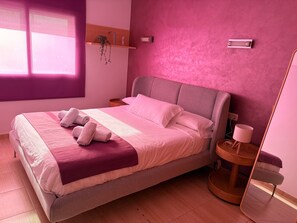 A modern bedroom with a bed, bedside tables, a mirror, and a window. - Coral Apartment: Exclusivity and Comfort in the Heart of Tossa de Mar (Tossa de Mar)