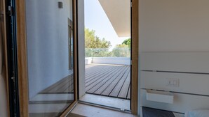 A room with a sliding glass door leading to an outdoor wooden deck. - Villa "The Beach" with Sea View, Shared Terrace & Wi-Fi (Pittulongu)