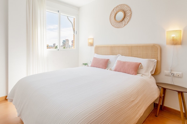 Une chambre avec un grand lit, un élément de décoration circulaire fixé au mur et deux lampes murales.