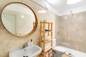 A bathroom with a sink, toilet, shower, and a wooden shelf with towels. - VV Isla Bonita- C - 84' with Sea View, Shared Pool and Wi-Fi (Los Cancajos)