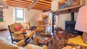 A rustic interior with exposed wooden beams, a fireplace, and a cozy seating area. - La Toumet – Family Home with Pool and Pyrenees View (MALABAT)