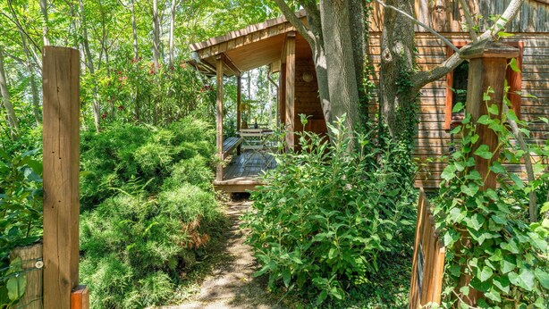 A rustic wooden structure with a wooden deck and a staircase leading to a covered area. - Chalet 'Gite Thym' with Shared Pool, Private Terrace and Wi-Fi (Mirabel-aux-Baronnies)