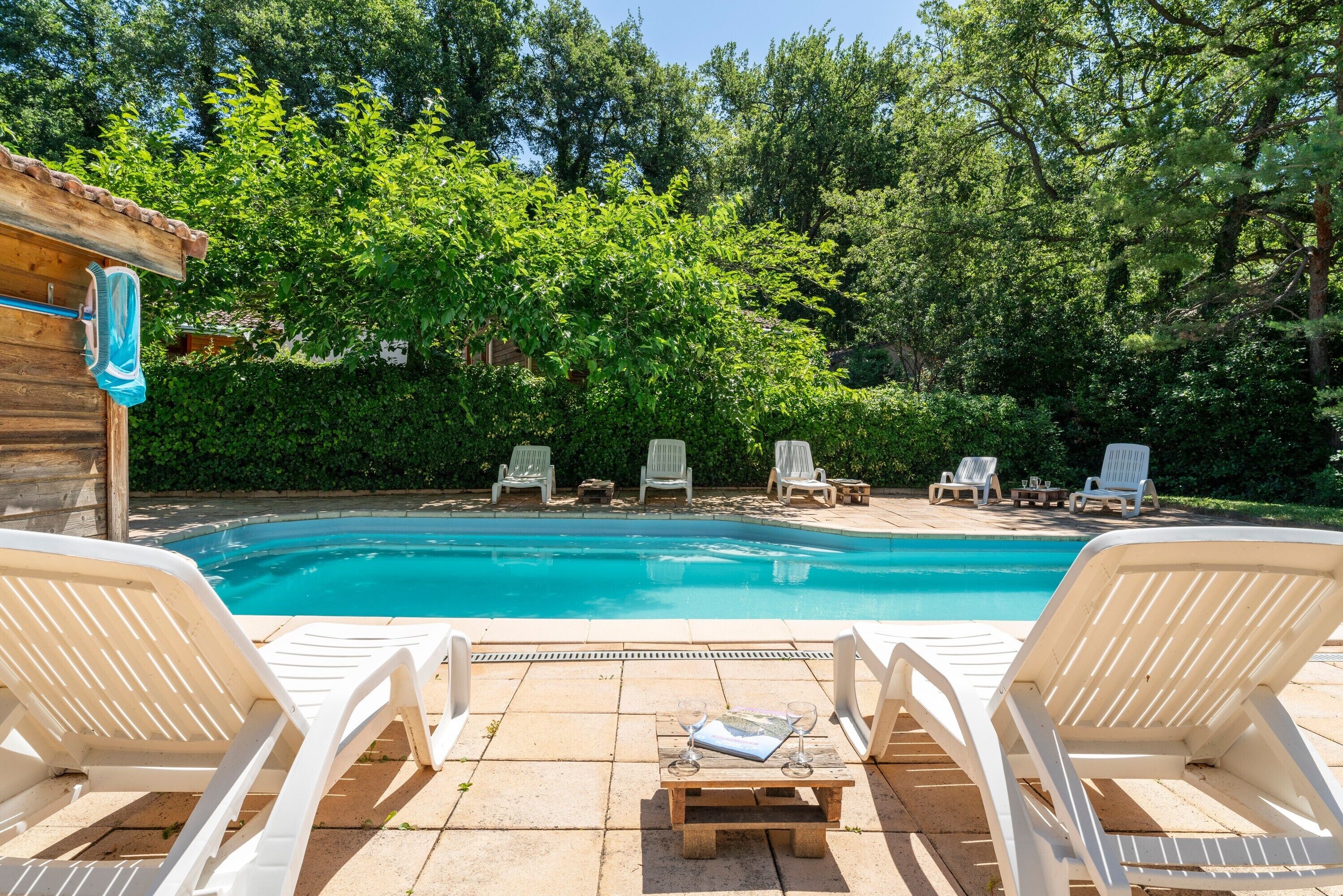 A swimming pool with lounge chairs and a wooden deck.