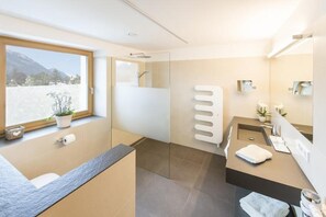 A modern bathroom with a shower, a sink, and a window with a view.