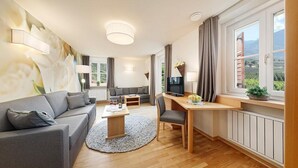 Una sala moderna con sofá, mesa de centro, televisor y comedor.