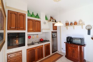 Kjøleskap, mikrobølgeovn, kokeplater og høy barnestol