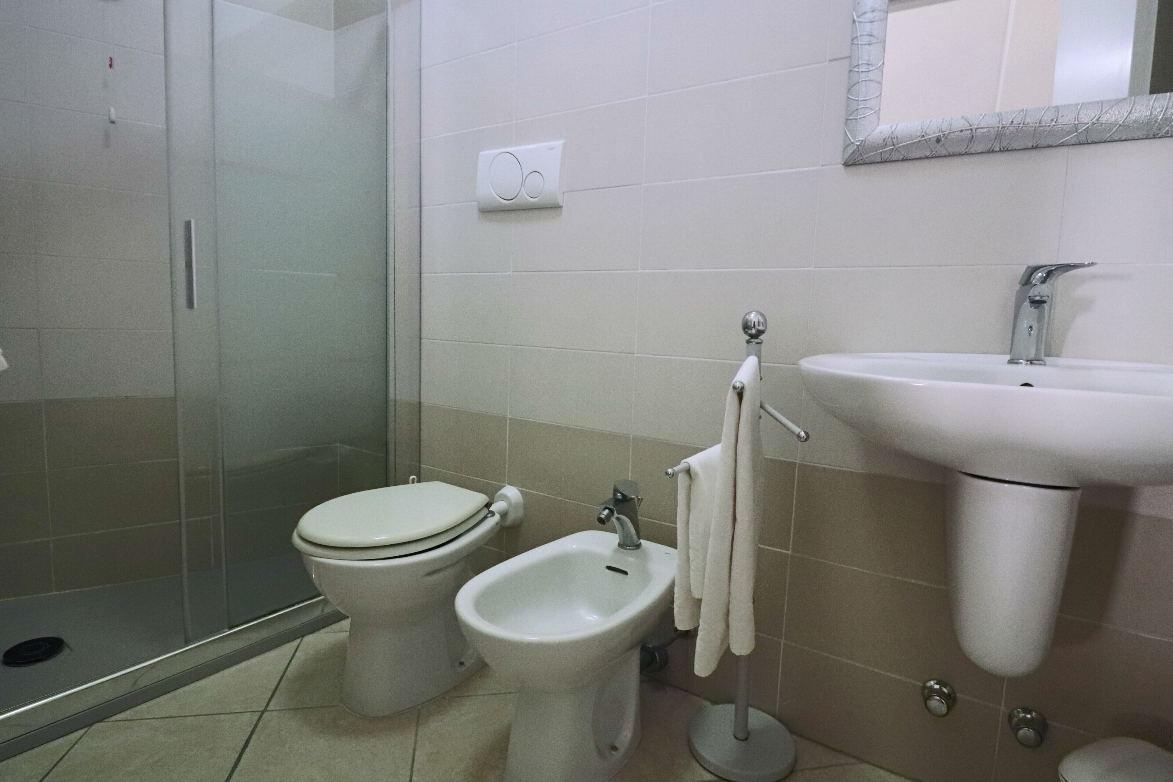 A bathroom with a toilet, bidet, and sink.