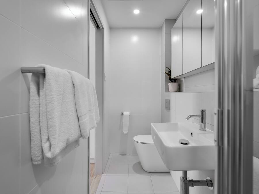 A modern bathroom with a toilet, sink, and towel rack.