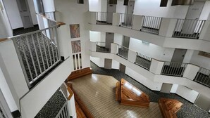 A multi-level atrium with a central open space, railings, and a patterned floor. - Palace 510 (Myrtle Beach)