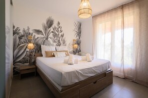 A bedroom with a large bed, bedside lamps, a nightstand, and a window with curtains. - Villa Halo, Lagoon Pool & Exclusive seaside getaway (Agde)