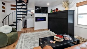 A modern living room with a black sofa, a green armchair, a black coffee table, and a fireplace. - Modern Mountain Apartment Unit 2 near Durango, CO. (Durango)