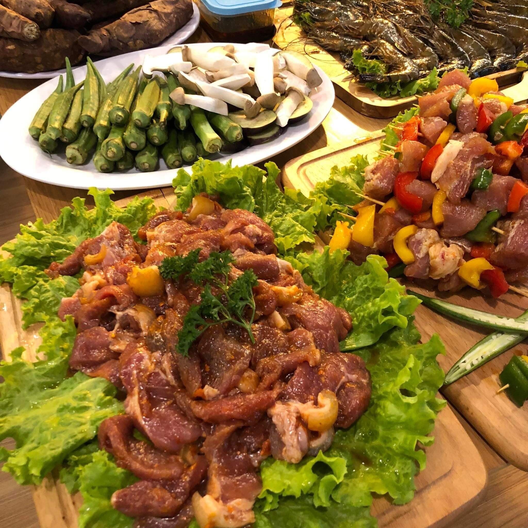 A variety of dishes including skewered meats, grilled vegetables, and a plate of sliced mushrooms.
