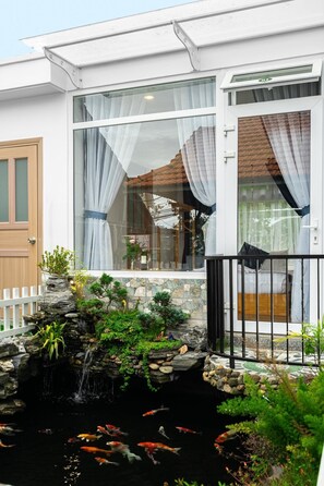 A modern house with a koi pond, a small waterfall, and a white picket fence. - Do Gia Bao Villa (Lam Vien - Da Lat)