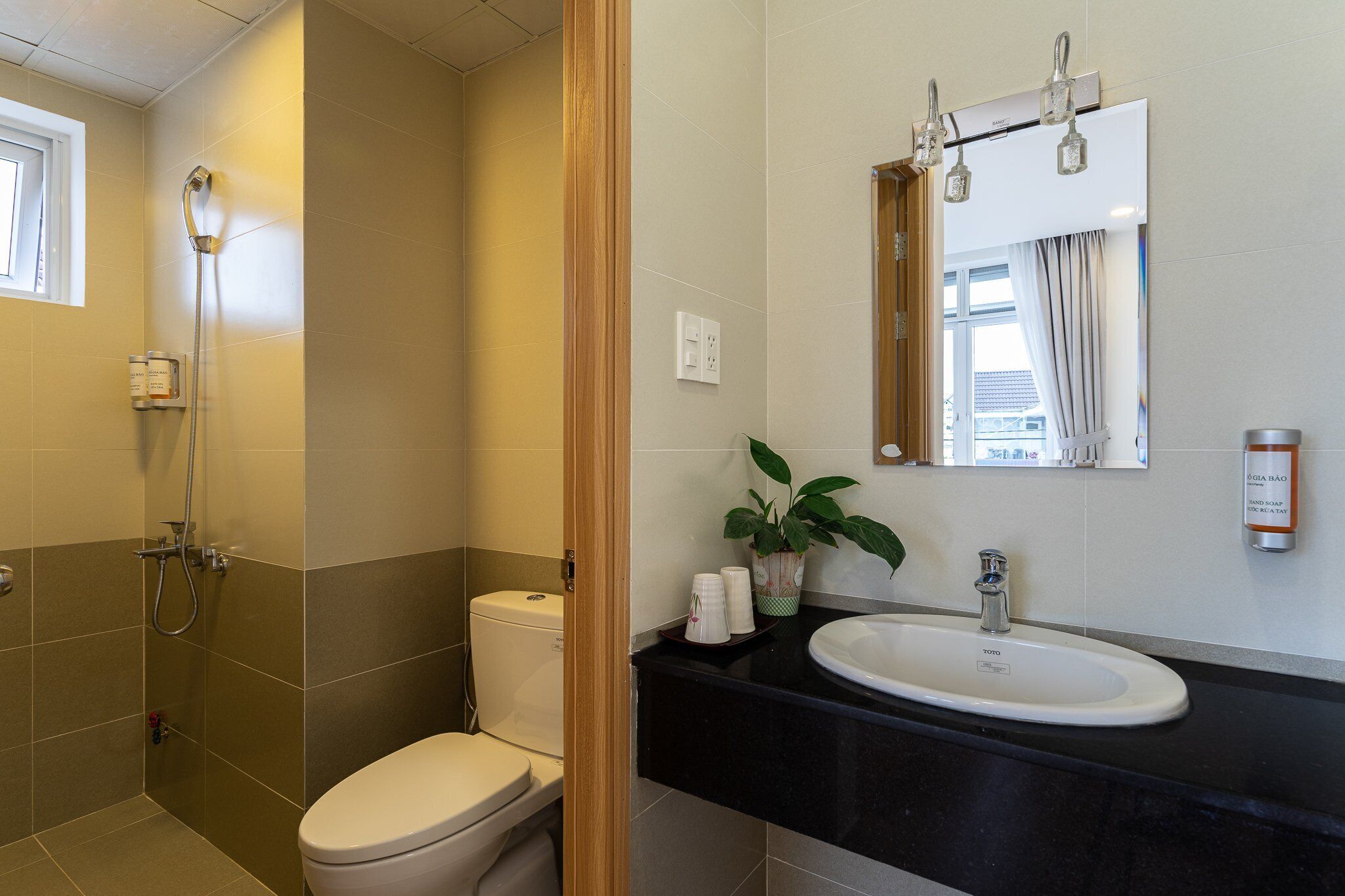 A bathroom with a toilet, shower, sink, and mirror.