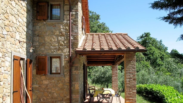 A stone building with a covered patio area, featuring a table and chairs, and a small garden area with plants. - Wonderful private villa for 6 people with private pool, WIFI, TV, terrace and pets allowed (Castiglion Fiorentino)