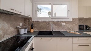 Eine moderne Küche mit großem Fenster, Einbauherd und Spüle.