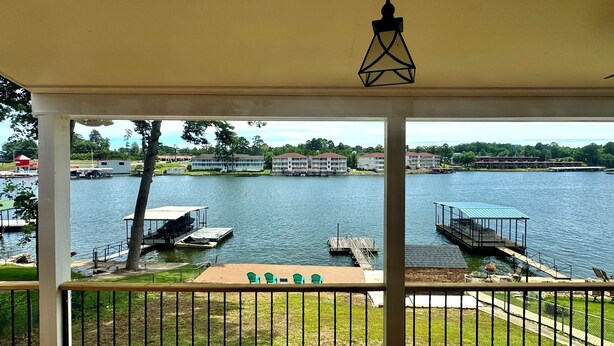 Blick vom Balkon auf einen See mit Stegen, einem Pavillon und Gebäuden im Hintergrund.