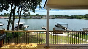 Ein Balkon mit Blick auf einen See, angestellte Boote und einen Gebäudekomplex gegenüber.