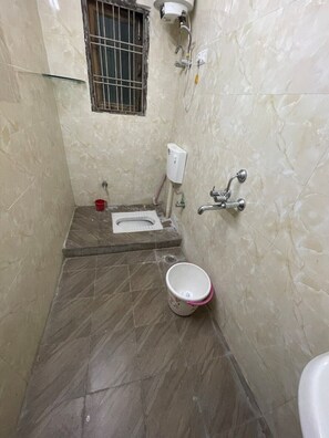 Bathroom features a shower, toilet, and soap dispenser.