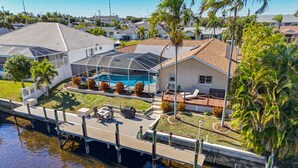 Propiedad residencial con piscina, muelle y abundante vegetación.
